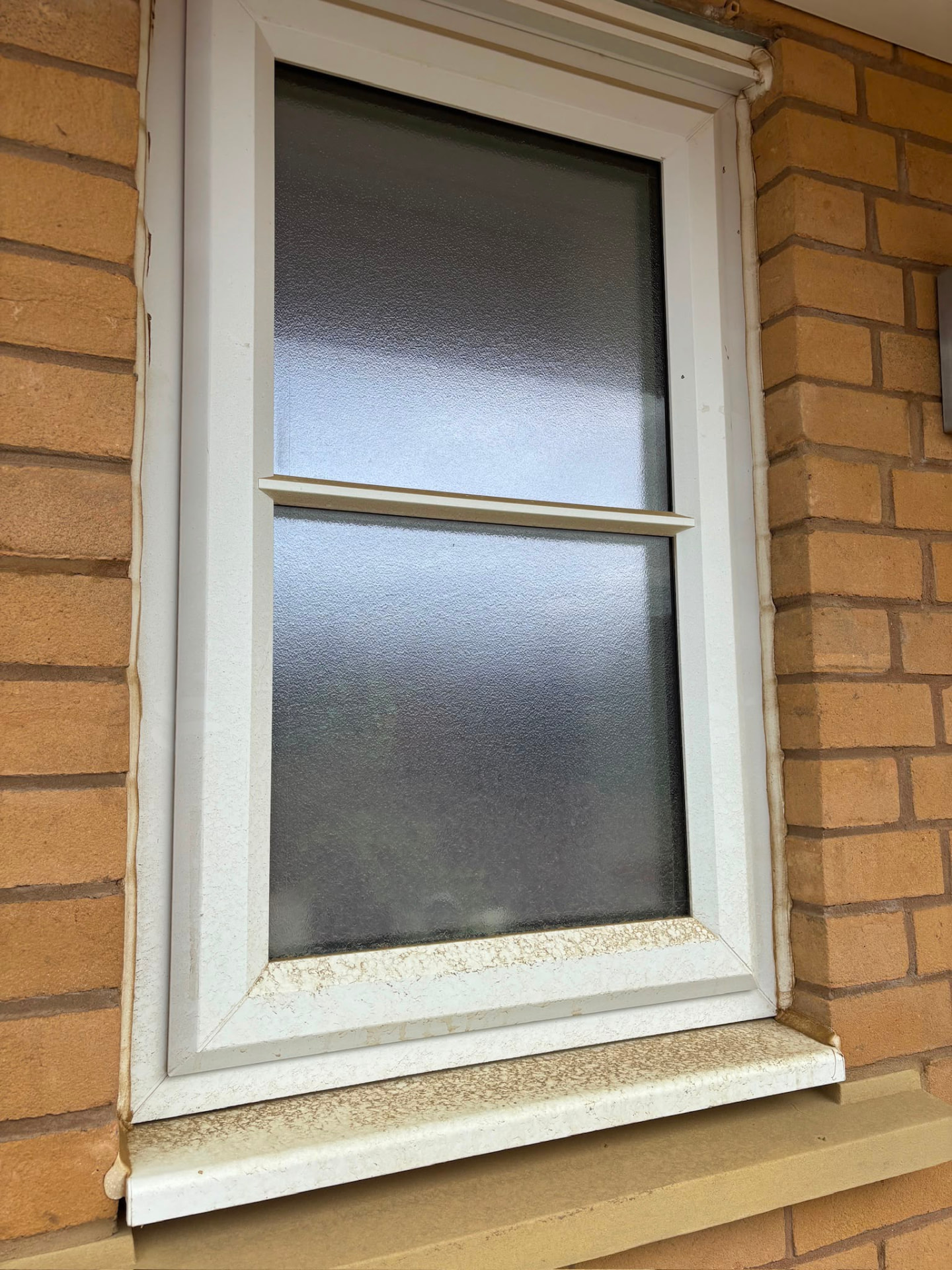 White uPVC window frame and sill before a full frame and sill clean