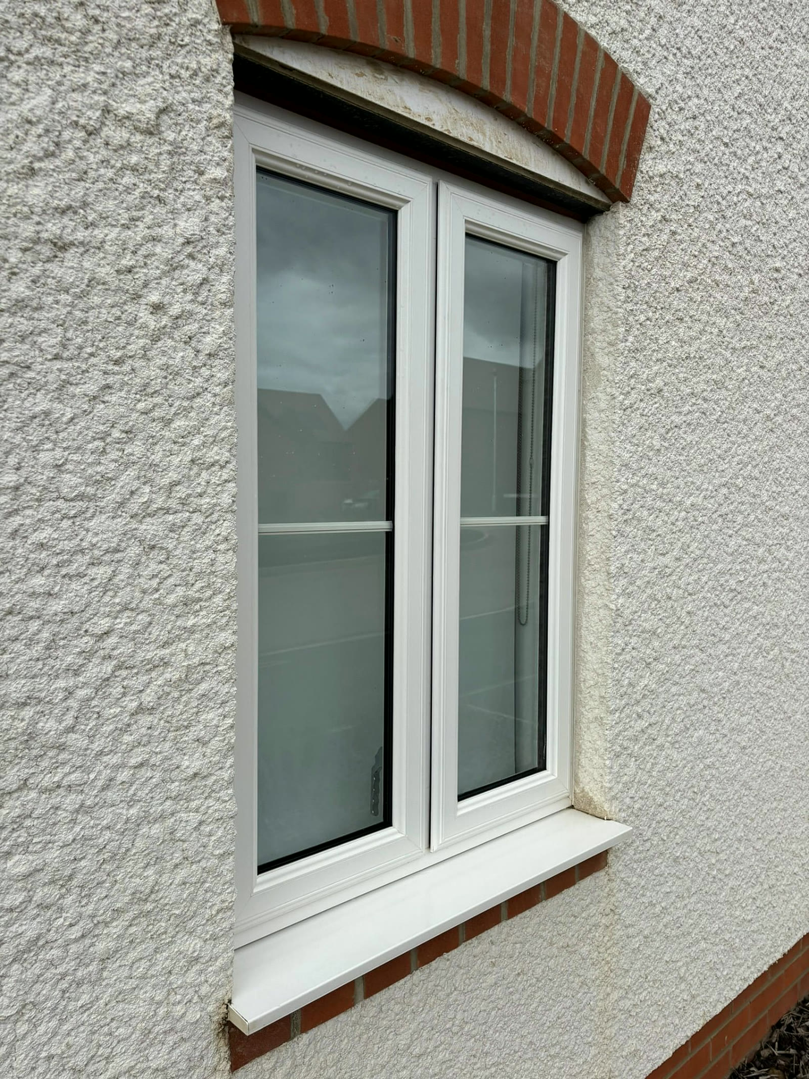 White uPVC cottage window and sill cleaned on a rendered house near Weedon